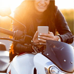 front-view-woman-looking-smartphone-while-sitting-her-motorcycle 2